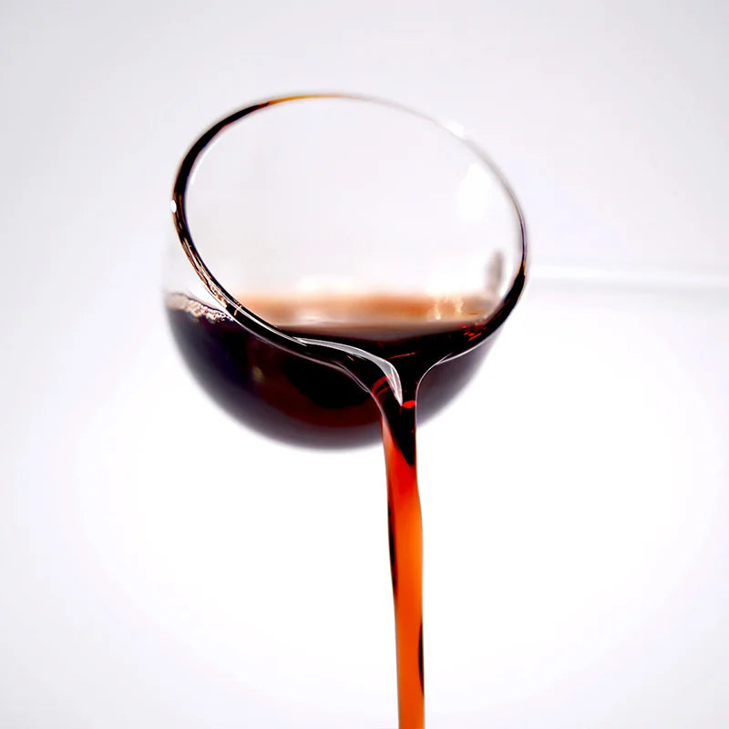 Close-up of blueberry concentrated syrup pouring, featuring a deep purple-red color and rich berry texture.