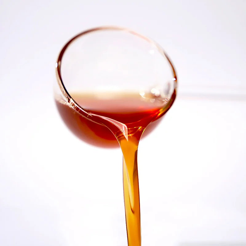 Close-up of kumquat lemon concentrated syrup pouring, showcasing a zesty amber glow and a perfect sweet-tart citrus balance.