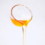 Close-up of lychee concentrated syrup pouring, showcasing a clear amber glow and enticing tropical fruity texture.