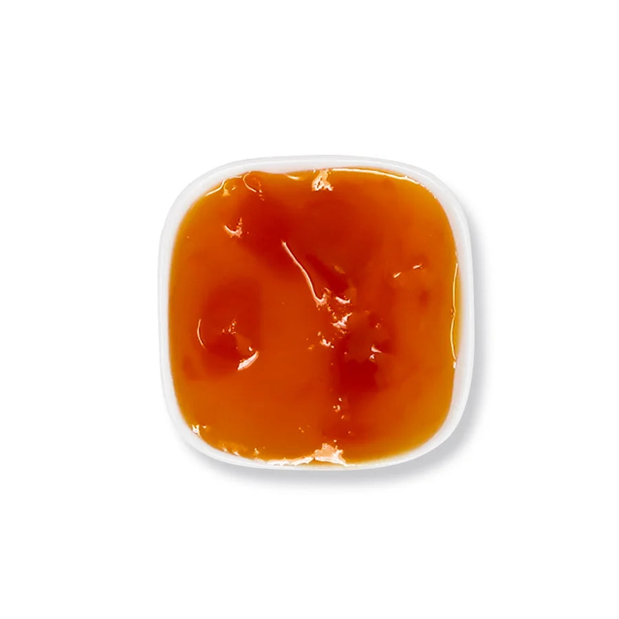 Close-up of mango jam texture, featuring rich fruit puree and pulp with a bright orange, natural preserve consistency.