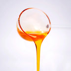 Close-up of peach concentrated syrup pouring, showcasing a translucent golden glow and rich, sweet peach aroma.