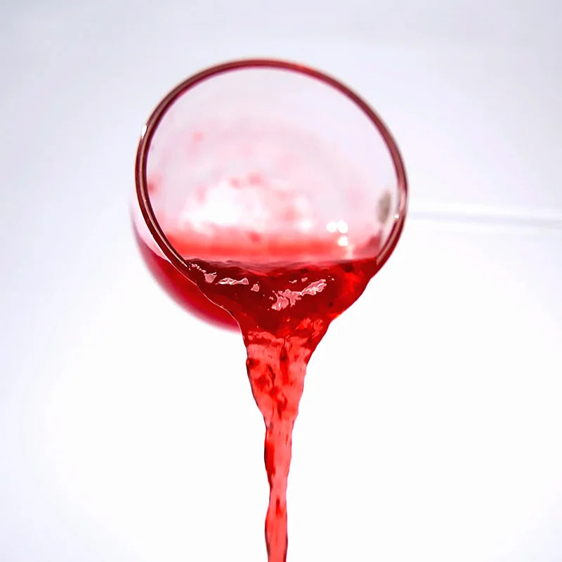 Close-up of strawberry concentrated syrup pouring, showing a vibrant red puree texture and sweet aroma.