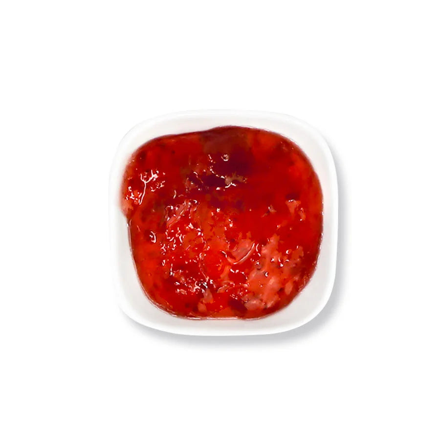 Close-up of strawberry jam texture, featuring rich red fruit puree and pulp with a natural preserve consistency.