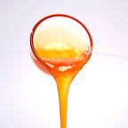 Close-up of passion fruit concentrated syrup pouring, featuring a seedless golden texture and smooth, rich fruity aroma.