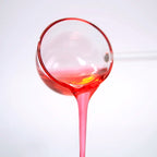 Translucent pink texture of Sakura syrup being poured, perfect for creating cherry blossom themed drinks.