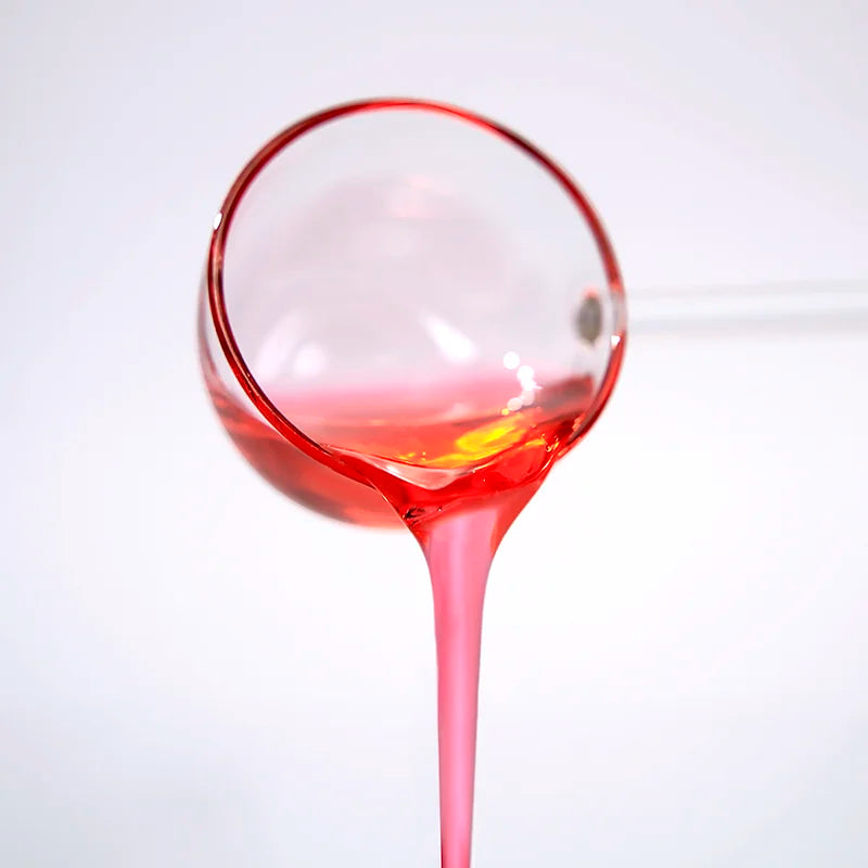 Translucent pink texture of Sakura syrup being poured, perfect for creating cherry blossom themed drinks.