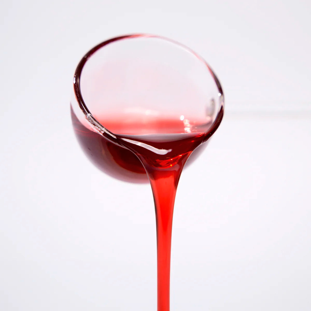 Close-up of professional hibiscus concentrated syrup pouring, showing deep ruby red color and viscous texture for bubble tea and cocktails.